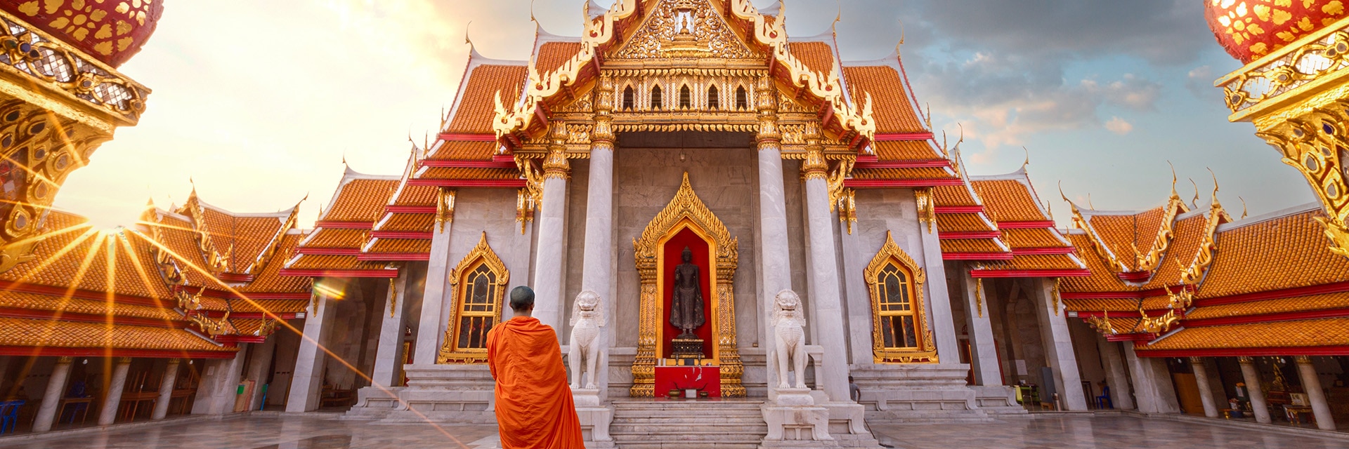 a monk stands infront of a temple located in laem chabang bangkok