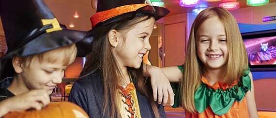 three children wearing costumes at camp ocean on a carnival cruise