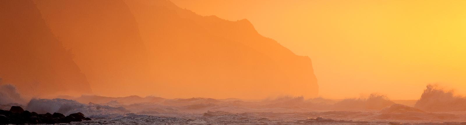 Waves crashing against rock formations in Kauai, Hawaii