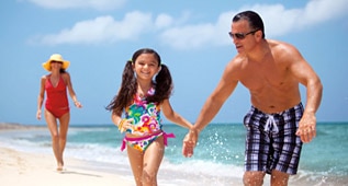 a woman, girl and man having fun at the beach