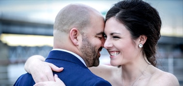 a newlywed couple hugging and smiling after their wedding